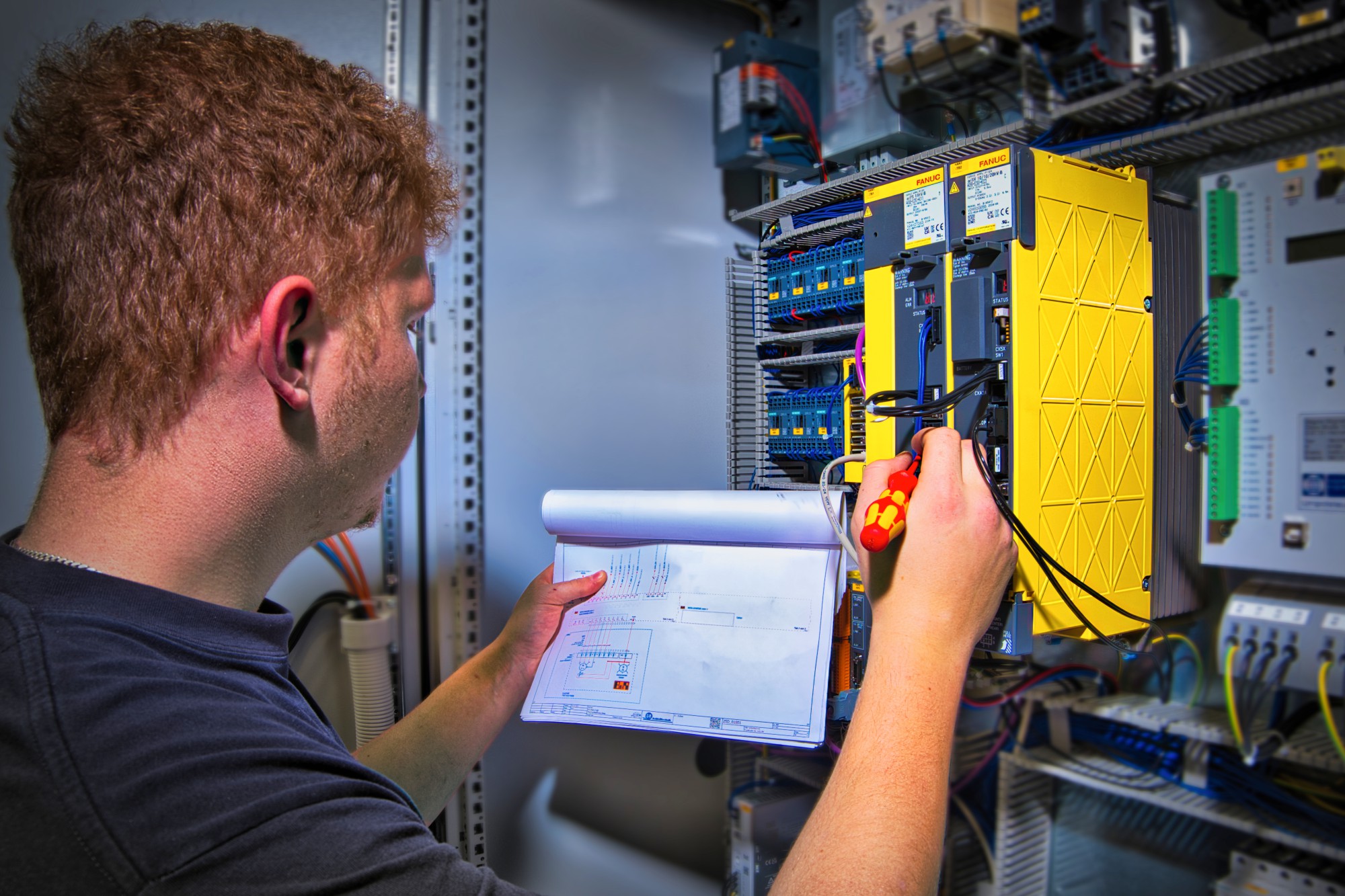 Elektroniker arbeitet an offenem Schaltschrank